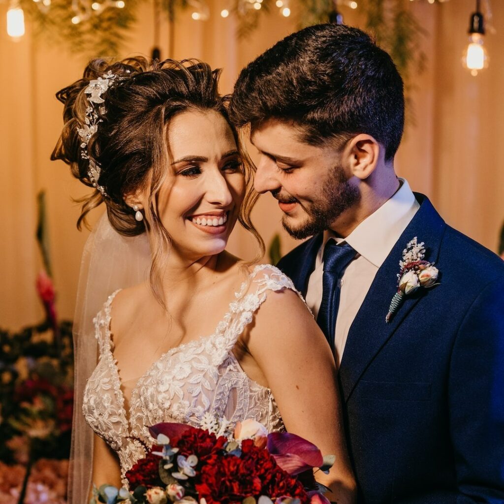 Noivos se olhando em frente ao altar sorrindo
