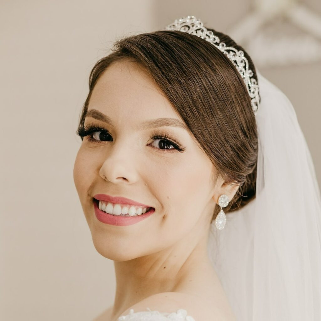Retrato de noiva maquiada sorrindo enquanto olha para a camera
